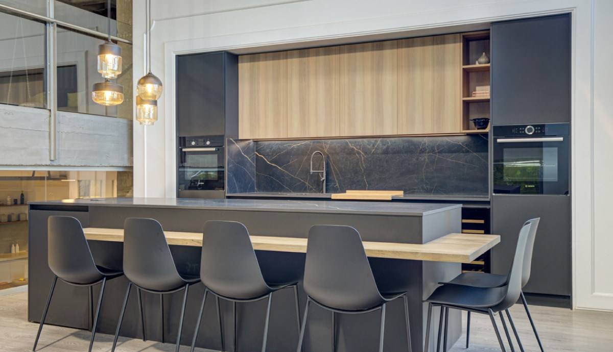 Cocina integral gris con isla y barra de madera