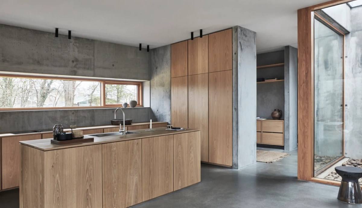 Cocina de madera con isla y muros de concreto aparente